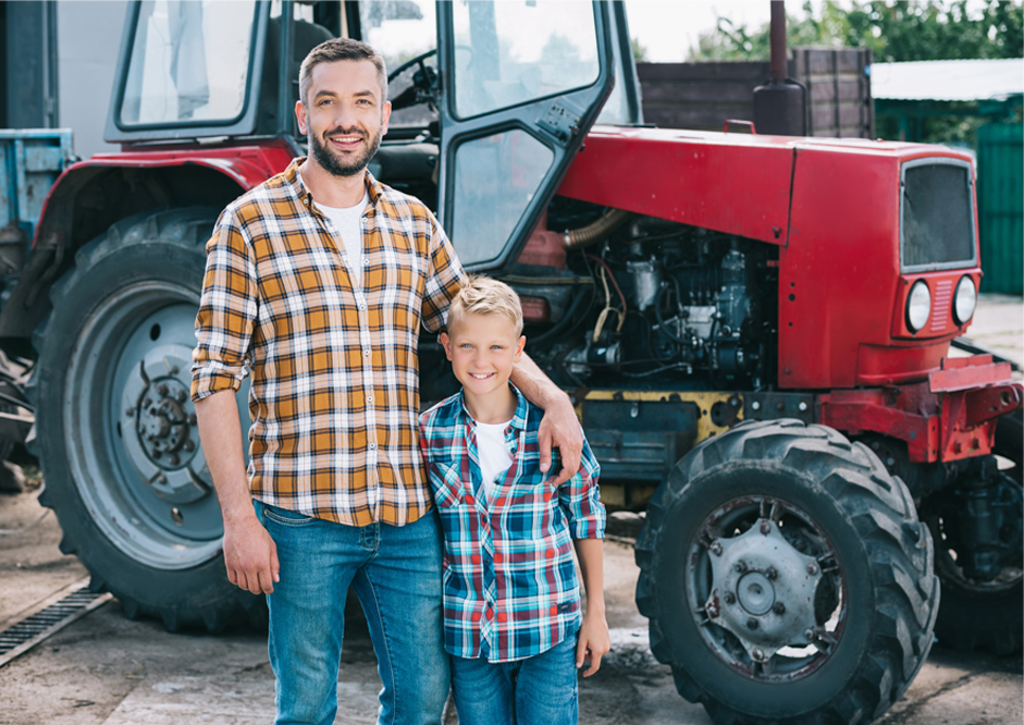 father and son standing near tractor